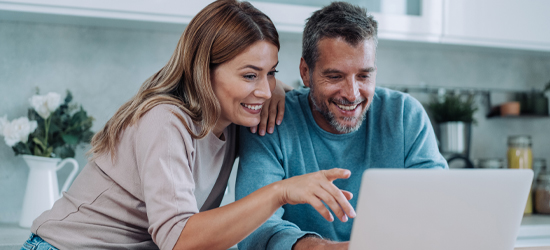 Couple pointing and looking at computer