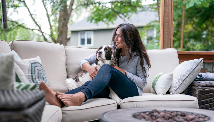 woman on patio sofa with dog