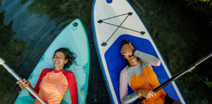 happy friends laughing on paddleboards